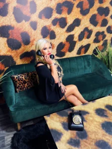 Brooke sitting on black couch with leopard print wall